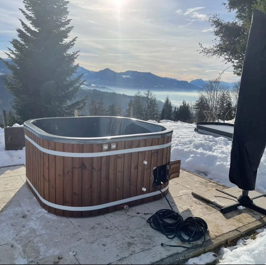 Drewniana balia ogrodowa z hydromasażem w otoczeniu zieleni